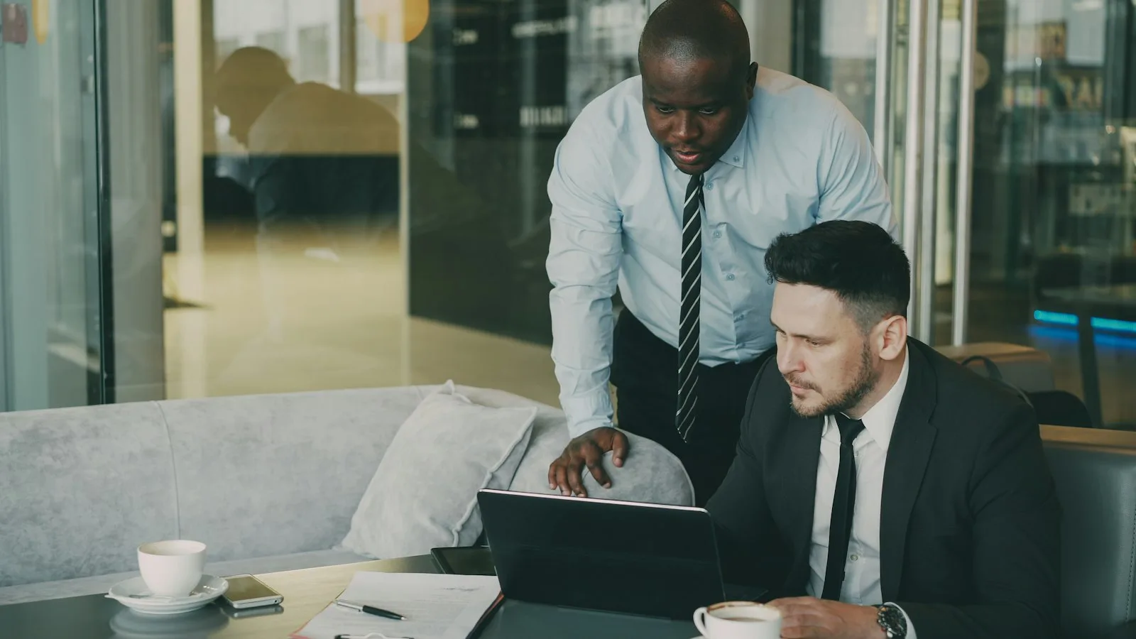 Cómo cobrar de tu SL Dos socios de una empresa revisando números con el portátil